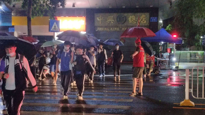 晚上9点多，福田区退役军人志愿者在雨中护送学子放学.png