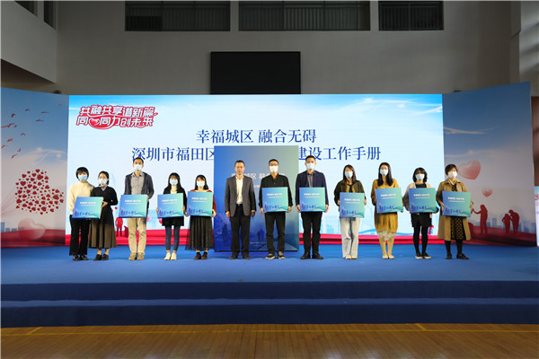 福田区政府副区长朱伟华（左六）为各街道残联代表发放《幸福城区 融合无碍——深圳市福田区无障碍城区建设工作手册》.JPG