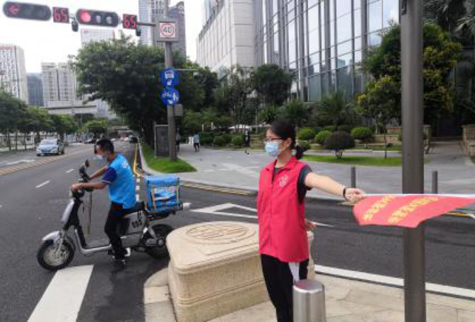 志愿者走上街头摆放乱停的共享单车，进行交通文明劝导.png