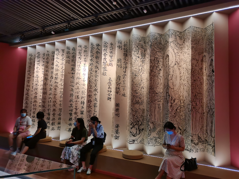 Visitors rest in front of an installation printed with Buddhist scriptures. Photo by Cao Zhen.jpg