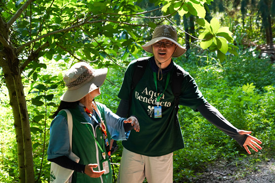 A delegate talks with a volunteer while exploring the Moon Tao educational trail at OCT Wetland on Friday._副本.jpg